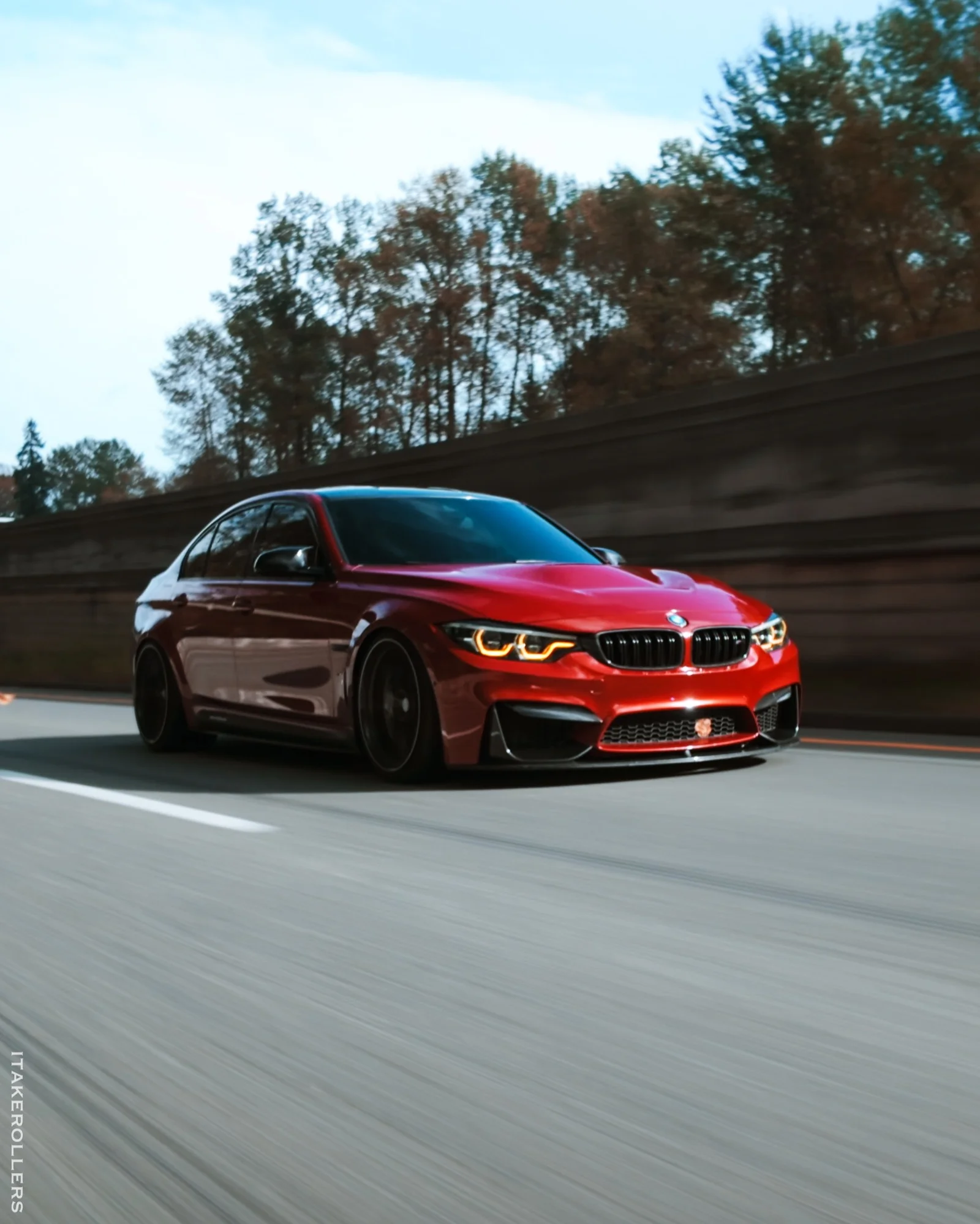 Red BMW M3 rolling angle shot
